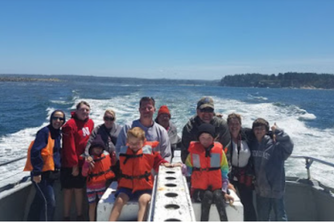 a group of people standing next to a body of water